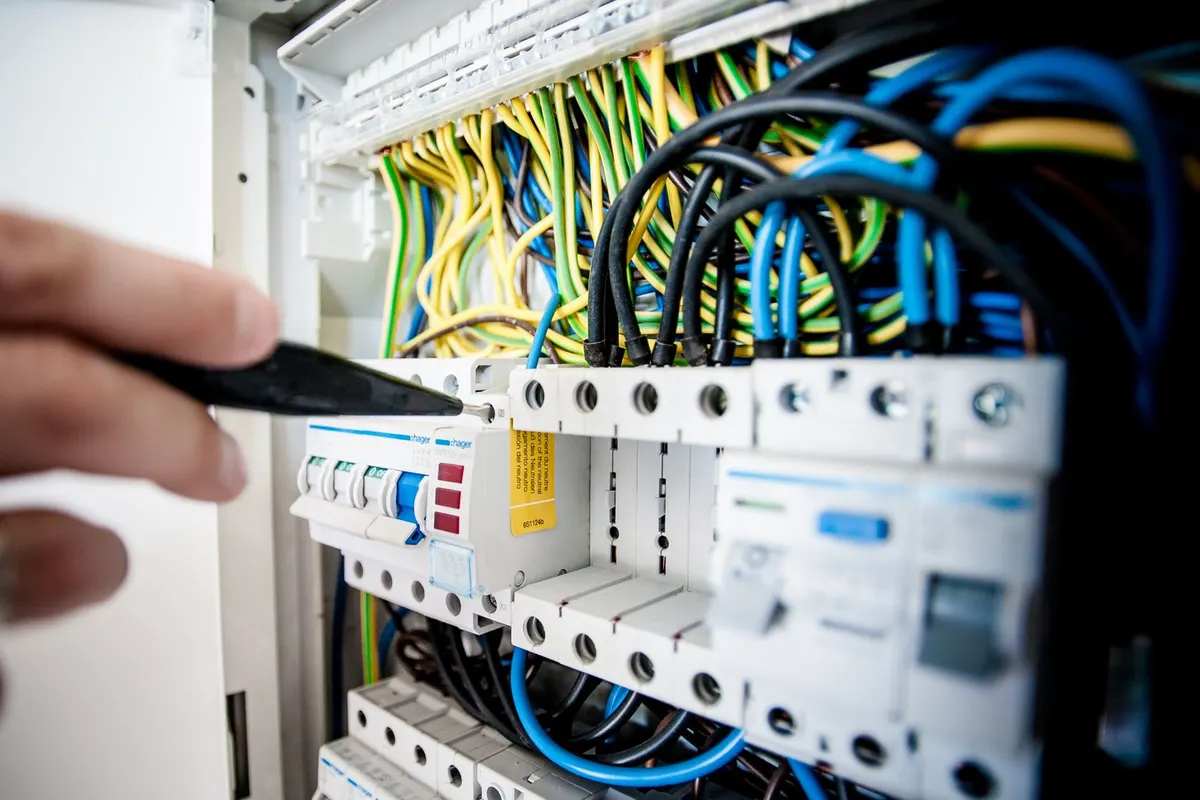 Électricien qui vérifie les disjoncteurs d'un tableau électrique